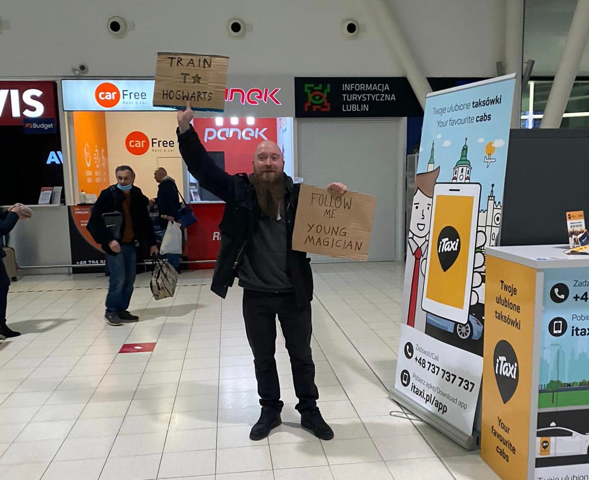 Man Holding up Sign at train station