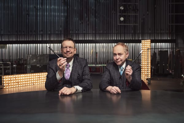 Penn & Teller with wands at table