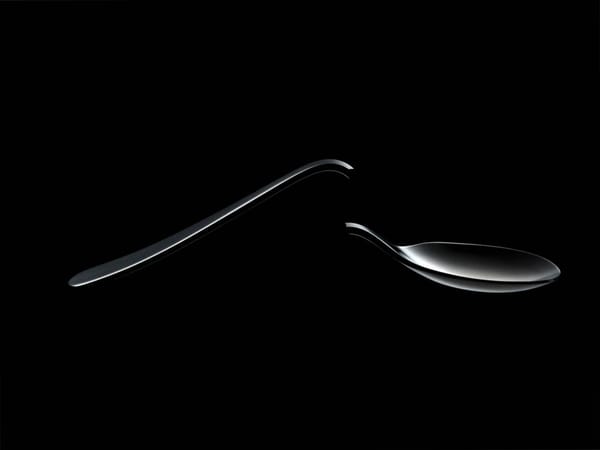 A bent spoon with a snapped point against a black background