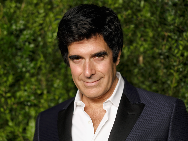 Las Vegas Magician and Illusionist David Copperfield in suit against green hedge