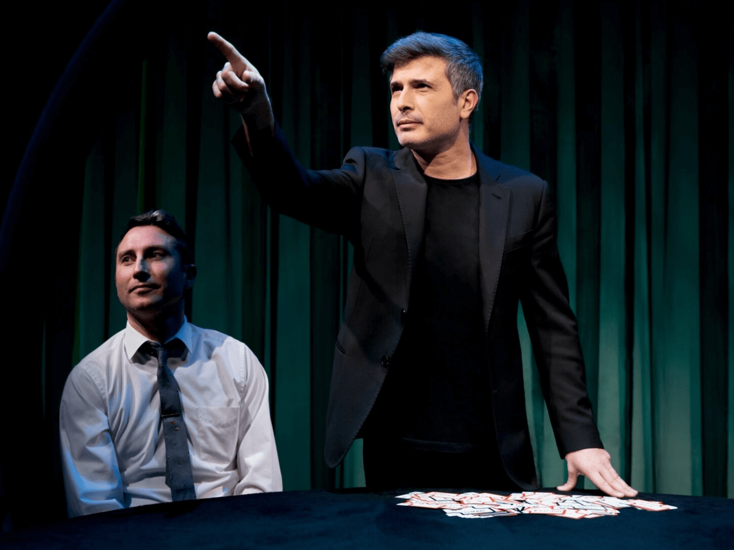 Magician Asi Wind performs with a deck of cards to a spectator in New York show Inner Circle