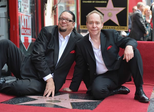 Magicians Penn and Teller sit next to their hollywood star on the walk of fame